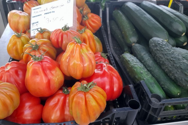 boxes with tomatoes and cucumber on display farm market in Portugal