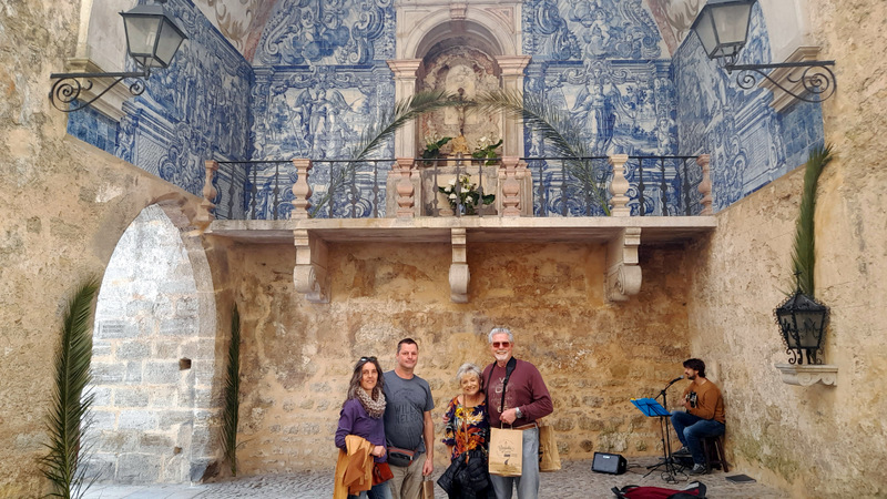 a group of people standing in front of a stone building obidos portugal