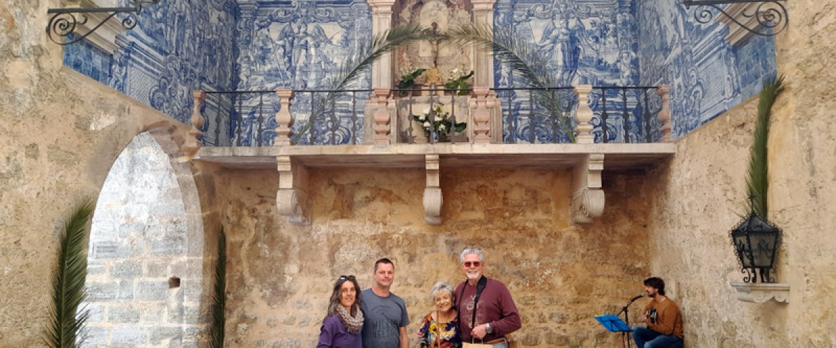a group of people standing in front of a stone building obidos portugal