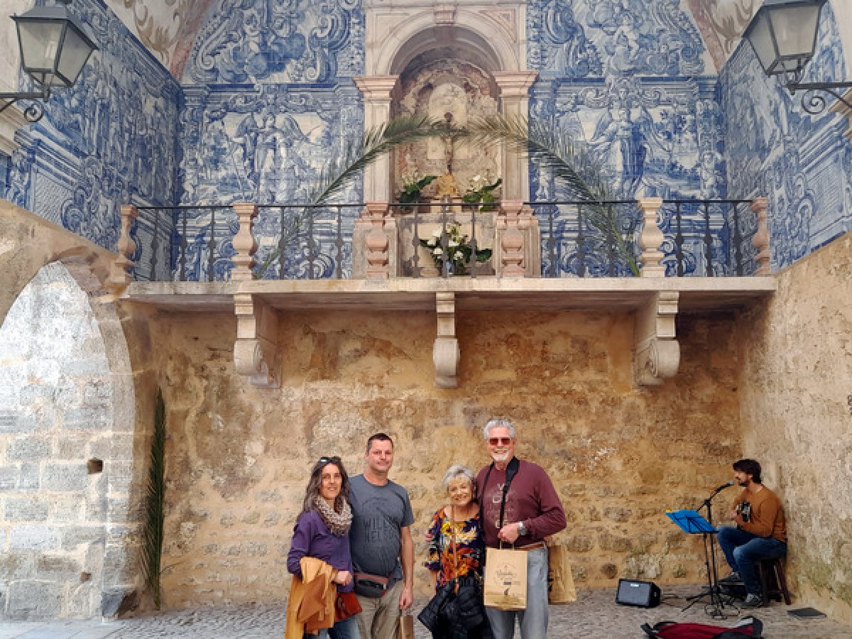 a group of people standing in front of a stone building obidos portugal