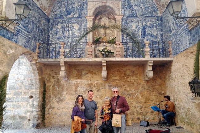 a group of people standing in front of a stone building obidos portugal