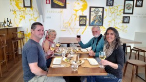 a group of people sitting at a dinner table posing for the camera sardine fatory tour
