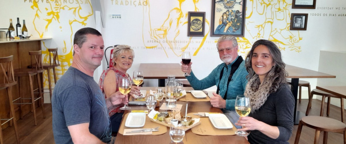 a group of people sitting at a dinner table posing for the camera sardine fatory tour