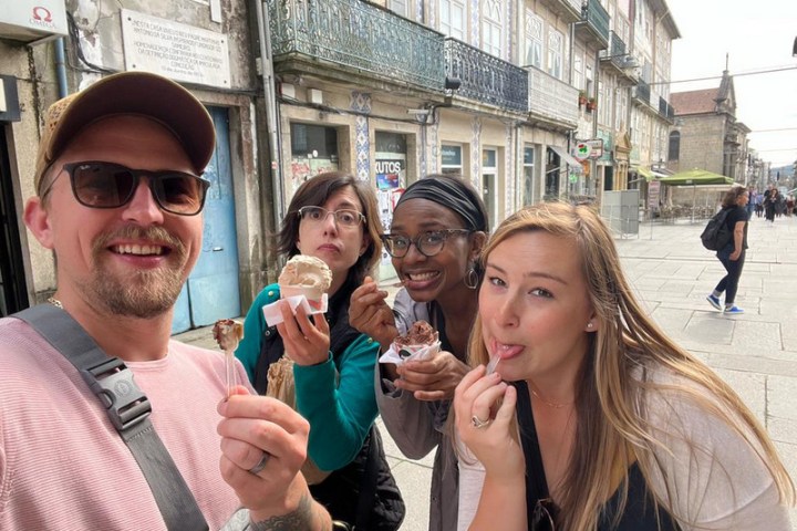 group happily take a selfie with their ice cream during a food tour in Braga, Portugal, sharing a fun experience.