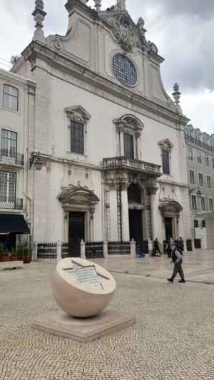 a statue of a person walking down the street during Lisbon tour