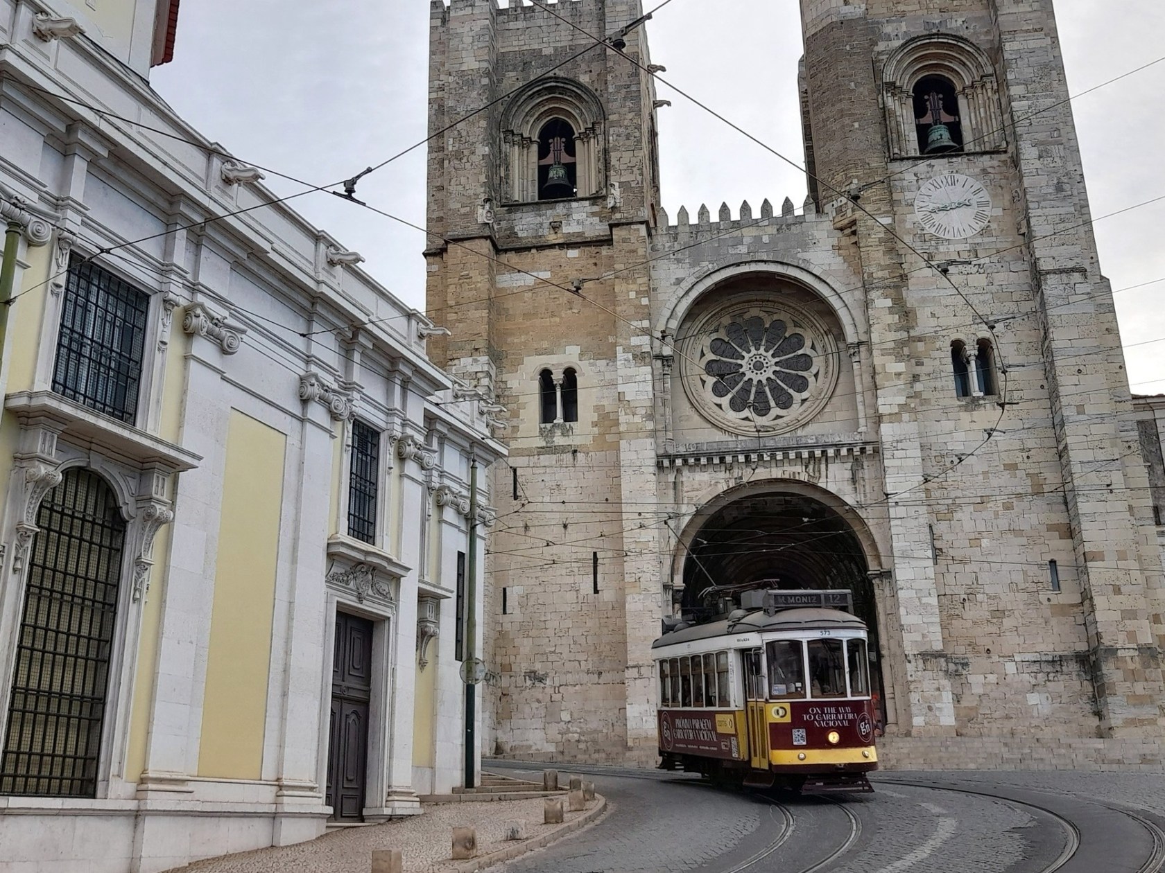 the yellow tram in front the cathedral in Lisbon