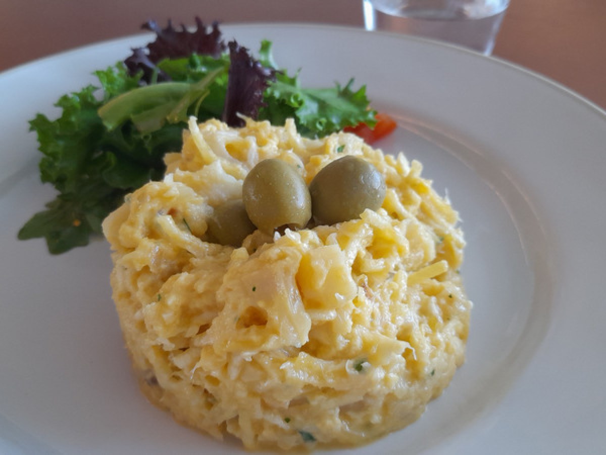 A colorful dish of salad and cod fish, highlighting the culinary delights experienced during Portugal cooking vacations.