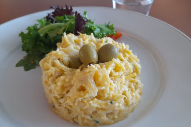 A colorful dish of salad and cod fish, highlighting the culinary delights experienced during Portugal cooking vacations.