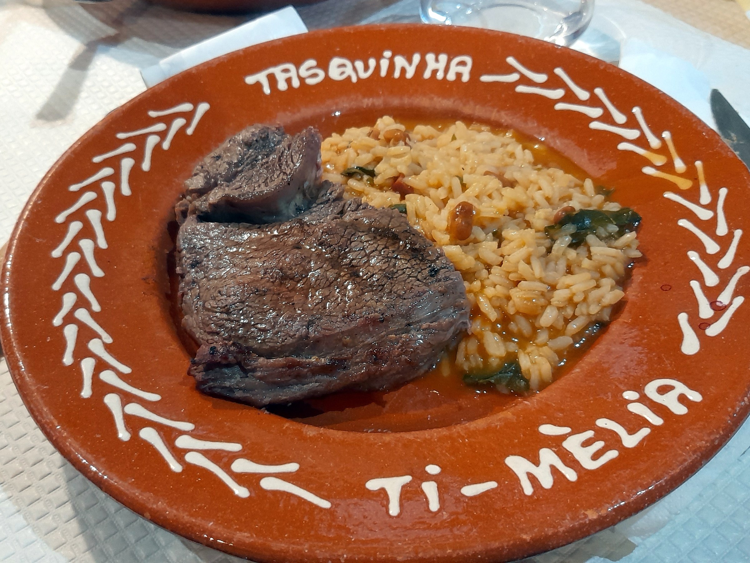 A delicious plate featuring cachena steak served alongside fluffy rice, ready to be enjoyed.