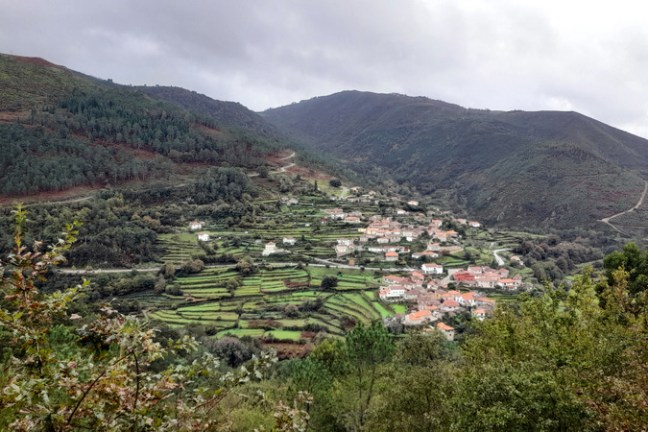 A picturesque mountain village in Sistelo, Portugal, surrounded by lush greenery and rolling hills, showcasing serene countryside beauty.