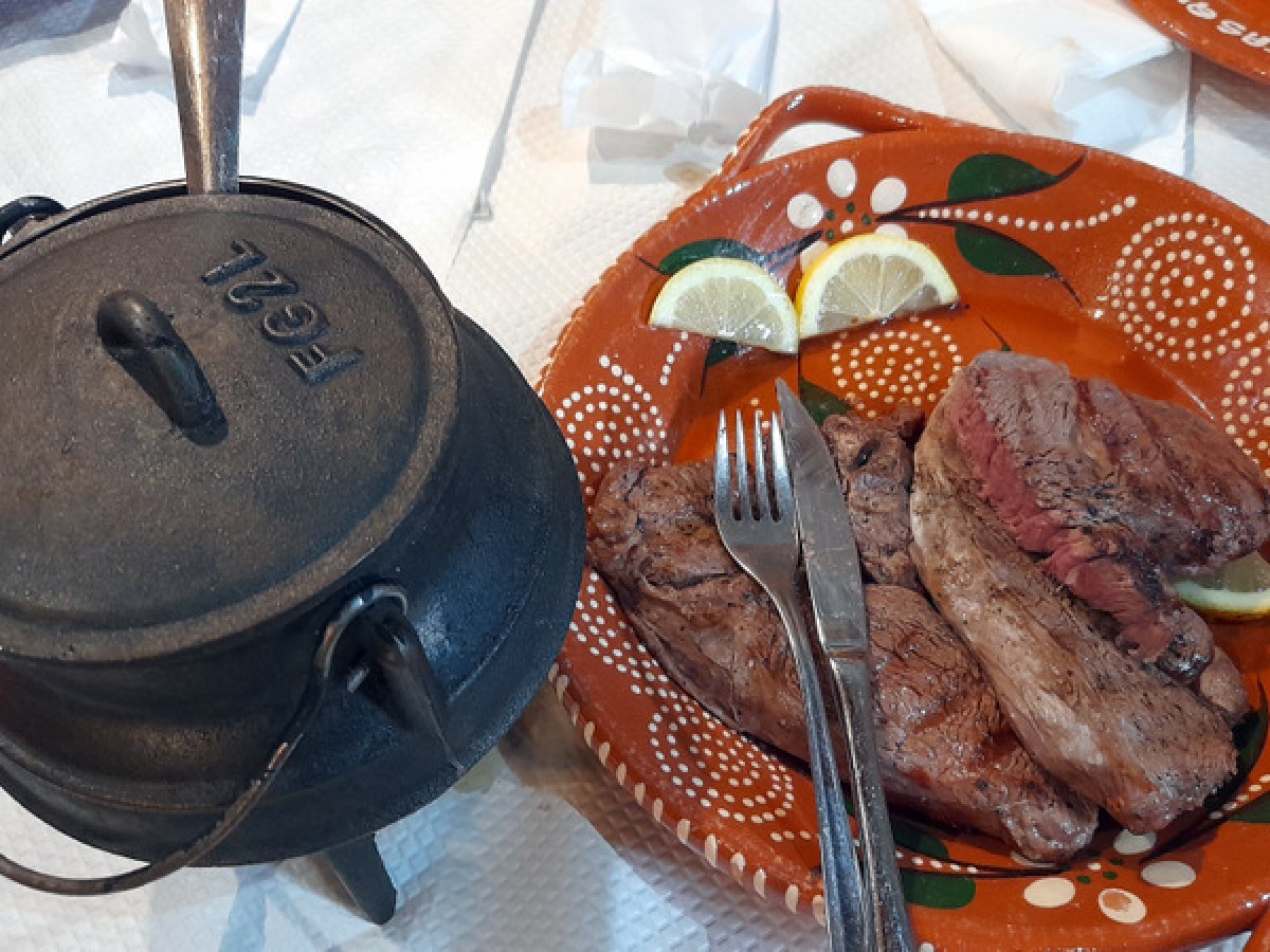 A beautifully arranged plate of traditional Portuguese cuisine sits invitingly on a rustic wooden table in a cozy restaurant.