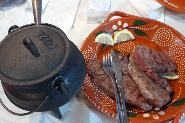 A beautifully arranged plate of traditional Portuguese cuisine sits invitingly on a rustic wooden table in a cozy restaurant.