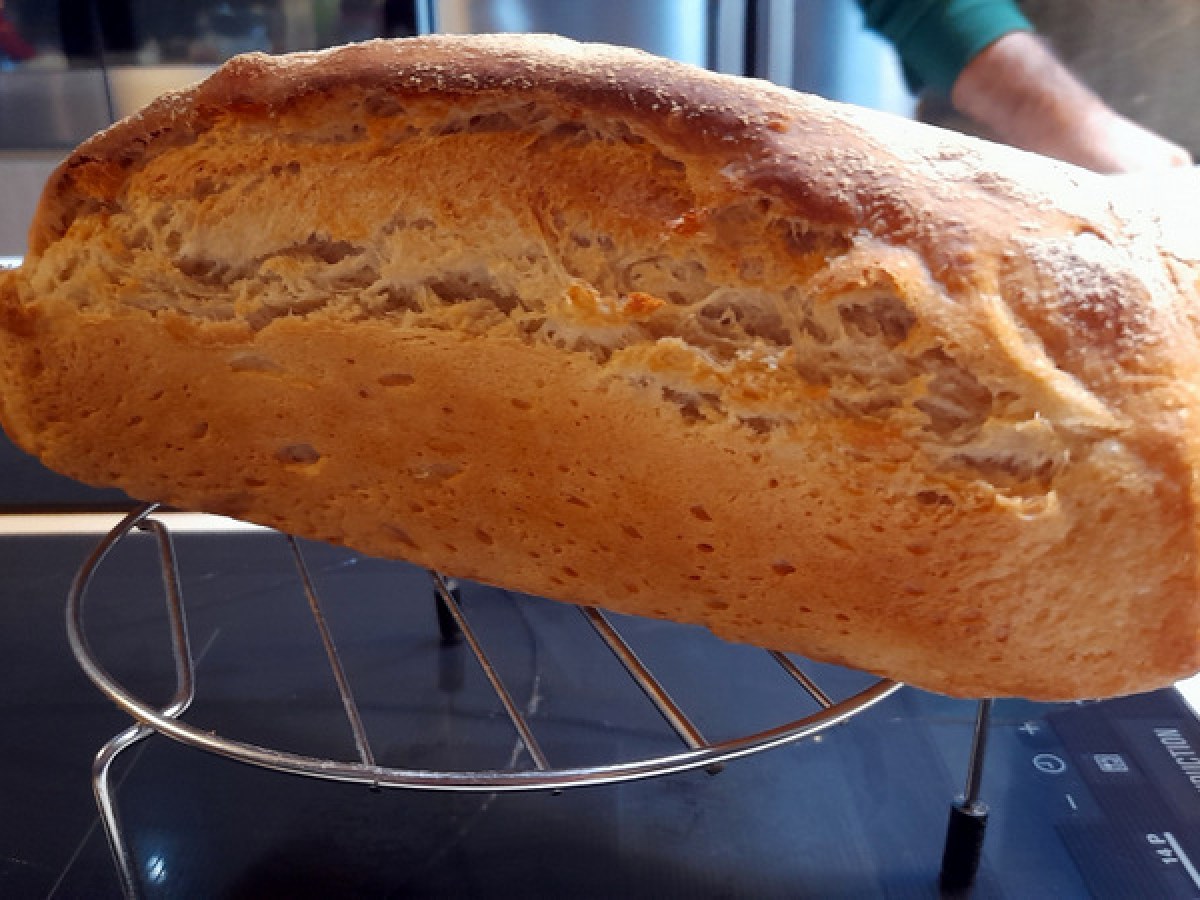 A rustic loaf of bread on a kitchen rack, showcasing the traditional recipe our guest learned in a cooking class in Portugal.