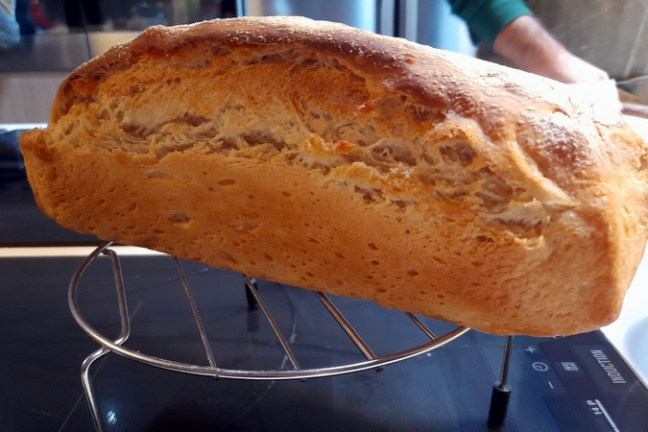 A rustic loaf of bread on a kitchen rack, showcasing the traditional recipe our guest learned in a cooking class in Portugal.