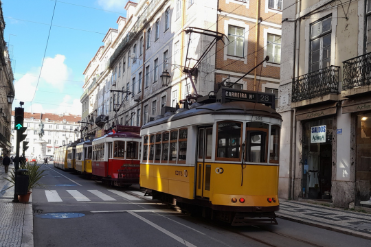 A lively Lisbon street adorned with a train, highlighting the excitement of exploring the city on a tour.