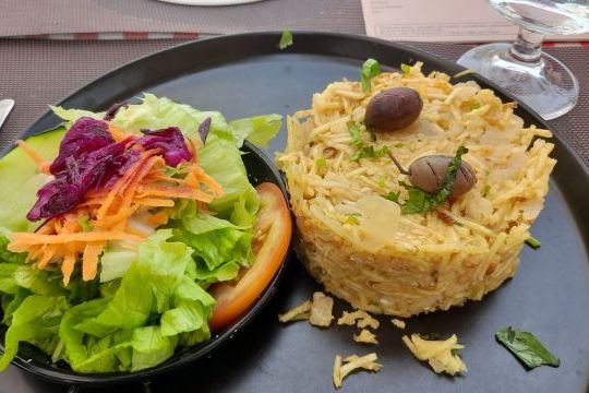 A vibrant plate featuring a fresh salad and cod fish, showcasing the flavors of Portugal's cooking vacations.