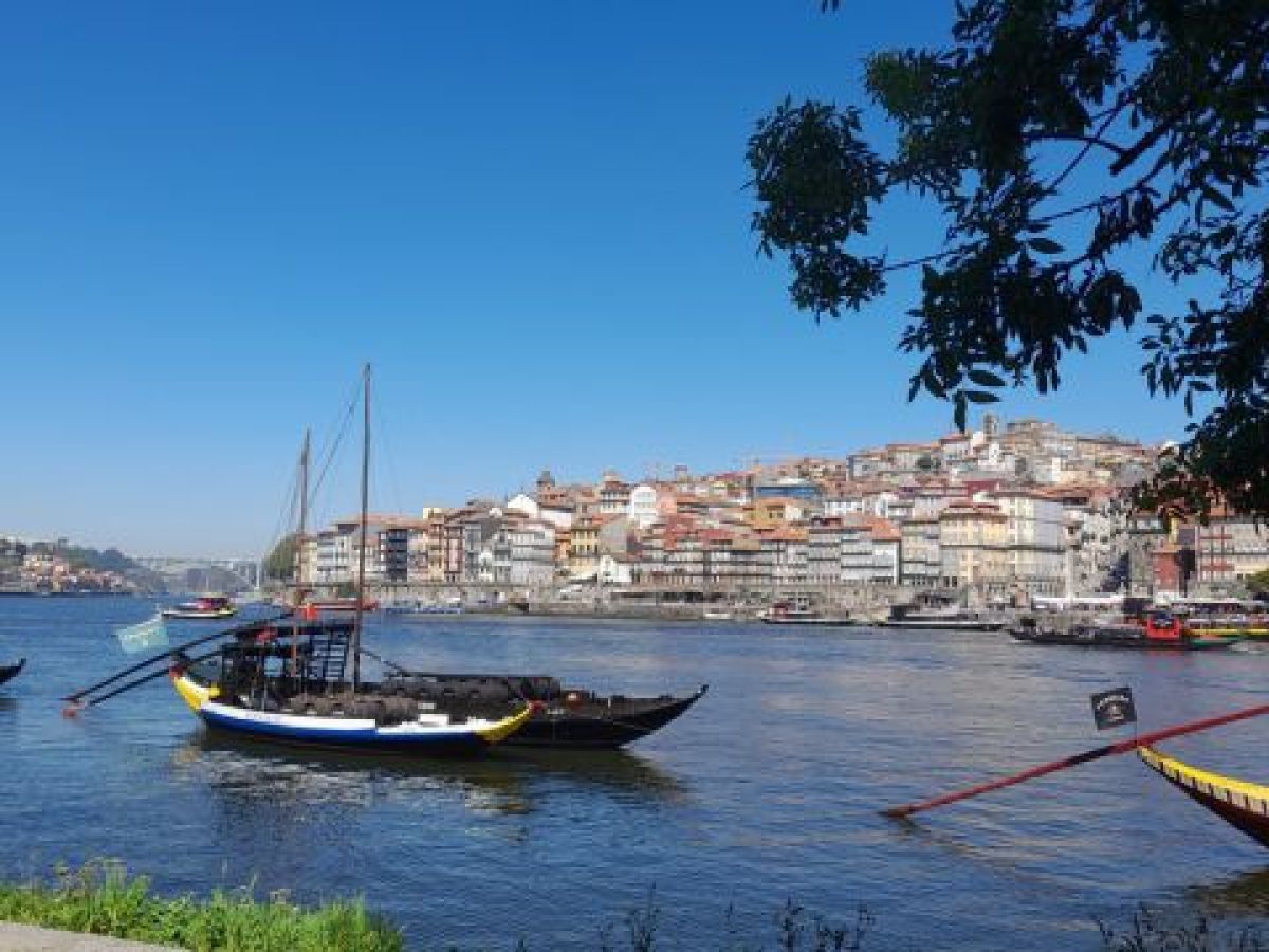 A serene boat floats on the Douro River, capturing the essence of Porto's cooking classes in a picturesque setting.