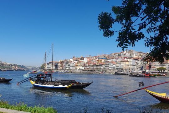 A serene boat floats on the Douro River, capturing the essence of Porto's cooking classes in a picturesque setting.