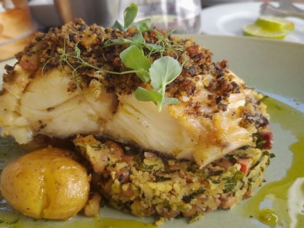 A delicious plate of food accompanied by a slice of bread, showcasing the culinary delights from our cooking retreat in Portugal.