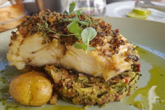 A delicious plate of food accompanied by a slice of bread, showcasing the culinary delights from our cooking retreat in Portugal.