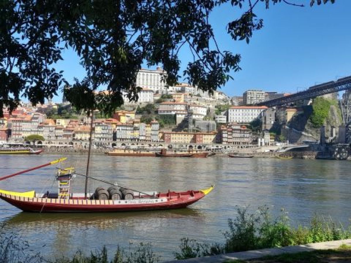 A serene boat gently floats on the Douro River, perfect for a family vacation in Portugal's stunning landscapes.