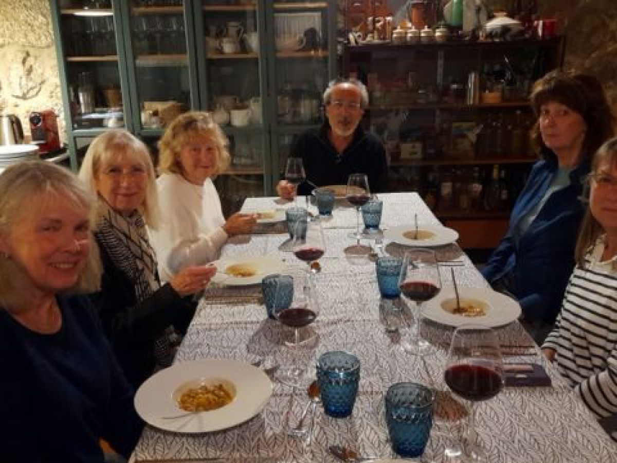 A small group of people enjoying dinner together at a table during a Culinary vacation in Portugal.