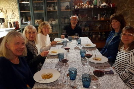 A small group of people enjoying dinner together at a table during a Culinary vacation in Portugal.
