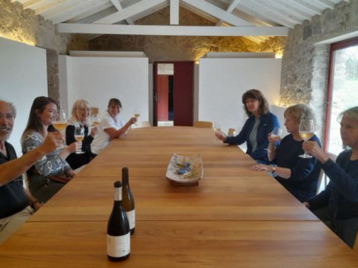 A group of friends enjoying a private wine tasting experience around a table during a cooking vacation in Porto, Portugal.