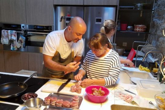 Two chefs in a warm kitchen, expertly preparing food for a memorable dinner during a small group culinary adventure in Portugal.