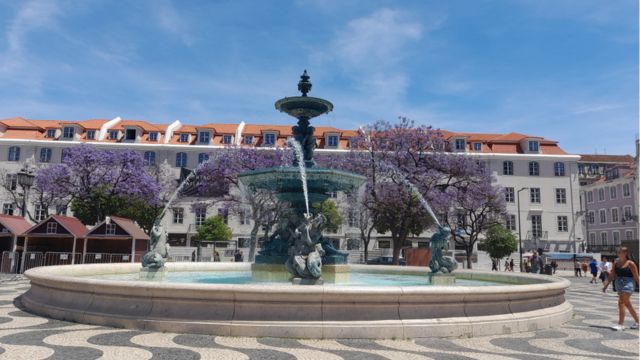 A charming city fountain surrounded by small groups enjoying their 7 Days in Portugal adventure from Lisbon.