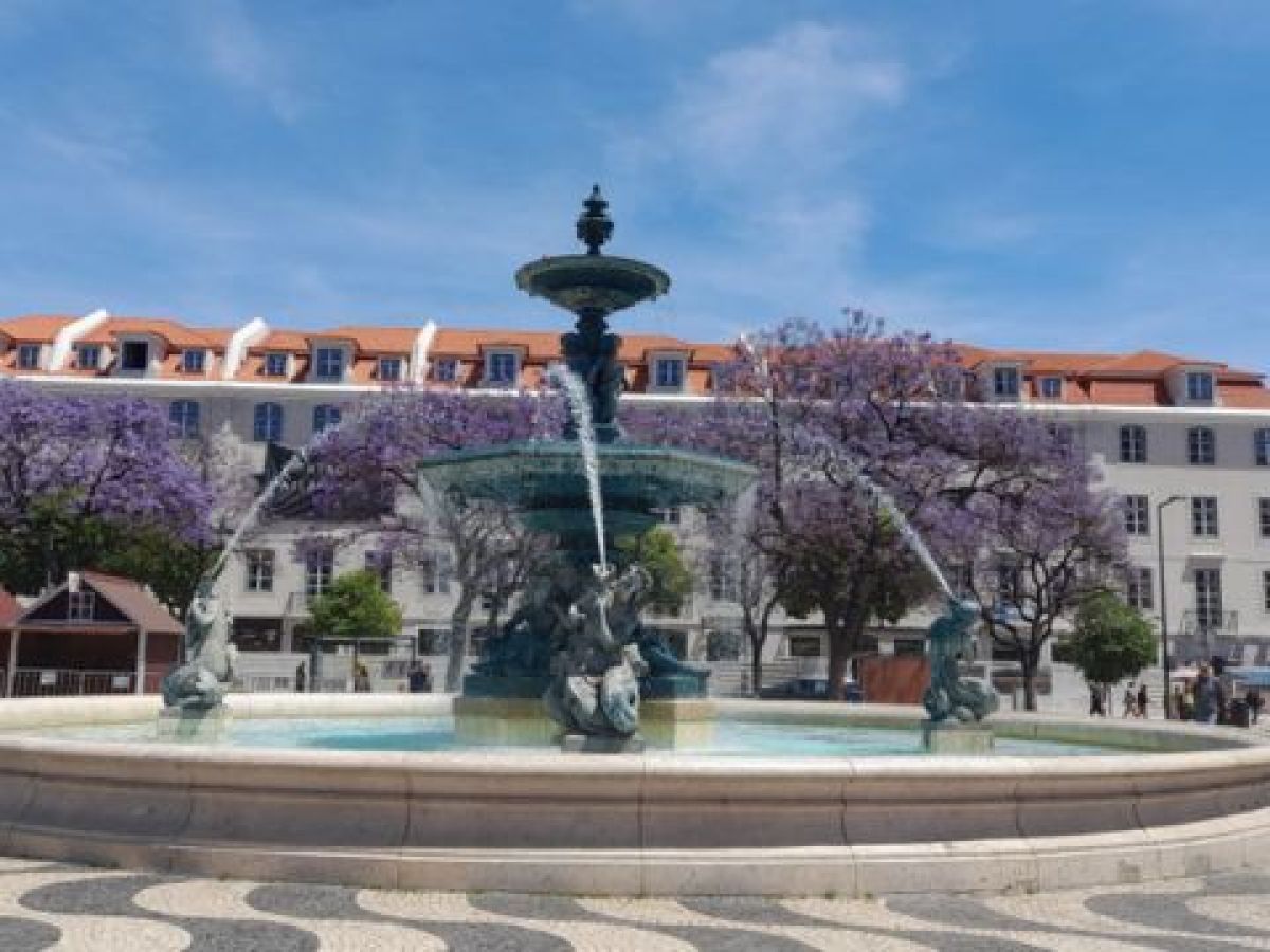 A charming city fountain surrounded by small groups enjoying their 7 Days in Portugal adventure from Lisbon.