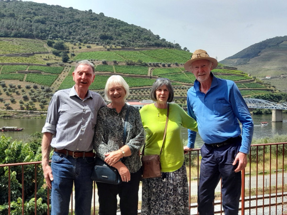 Four friends admire the scenic Douro valley from a bridge, capturing the essence of their small group journey in Portugal.