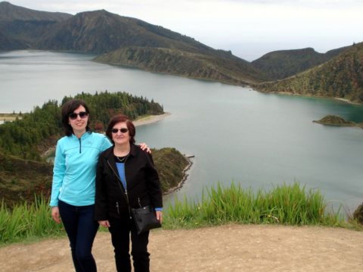 A mother and daughter admire the stunning lake view from a mountain during their Azores family adventure.