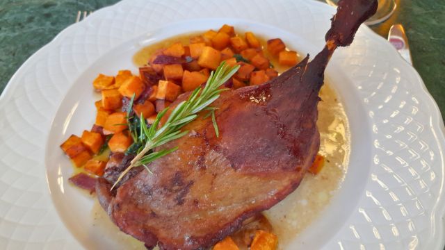 A delicious plate featuring roasted duck and golden potatoes, showcasing authentic Portuguese cuisine on a food tour.