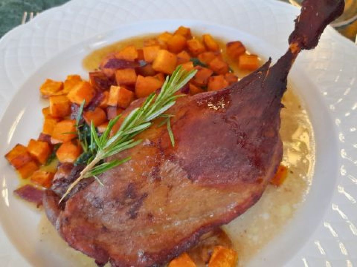 A delicious plate featuring roasted duck and golden potatoes, showcasing authentic Portuguese cuisine on a food tour.