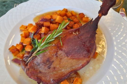 A delicious plate featuring roasted duck and golden potatoes, showcasing authentic Portuguese cuisine on a food tour.