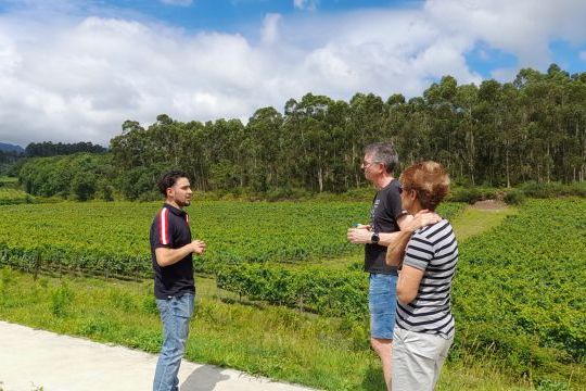 A man and woman stand on a scenic road in Portugal, surrounded by lush landscapes, ready for wildlife tours and winery visits.