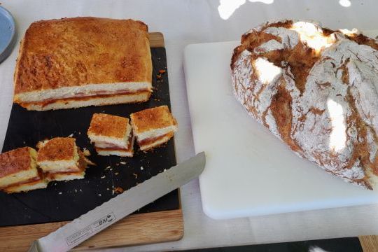 A picturesque table in the heart of Portugal's countryside, adorned with a knife and a loaf of bread, celebrating local culinary traditions.
