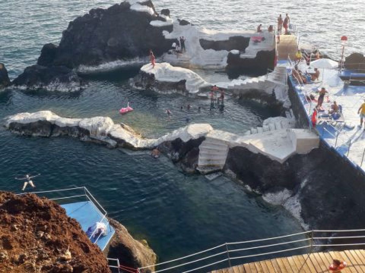 Scenic view of classic Madeira ocean tours, showcasing vibrant blue waters and stunning coastal cliffs under a clear sky.