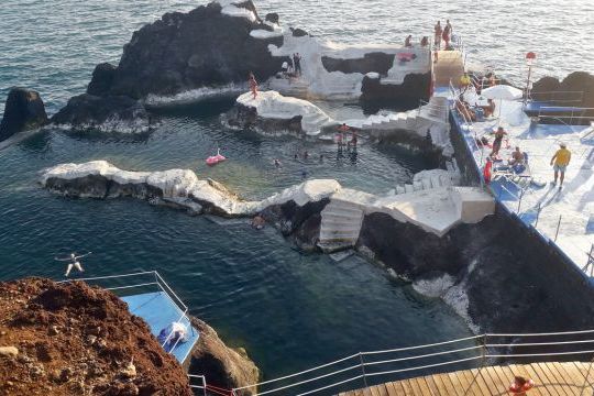 Scenic view of classic Madeira ocean tours, showcasing vibrant blue waters and stunning coastal cliffs under a clear sky.