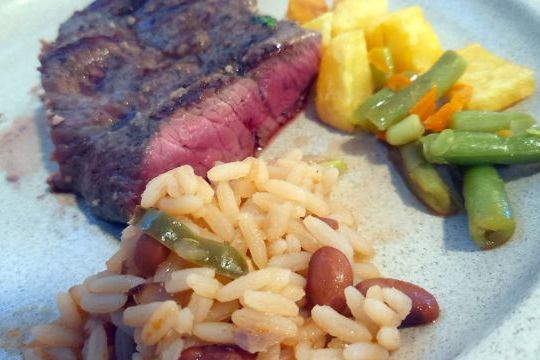 A delicious plate featuring Cachena steak, accompanied by beans and rice, perfect for a food and wine tour in Portugal.