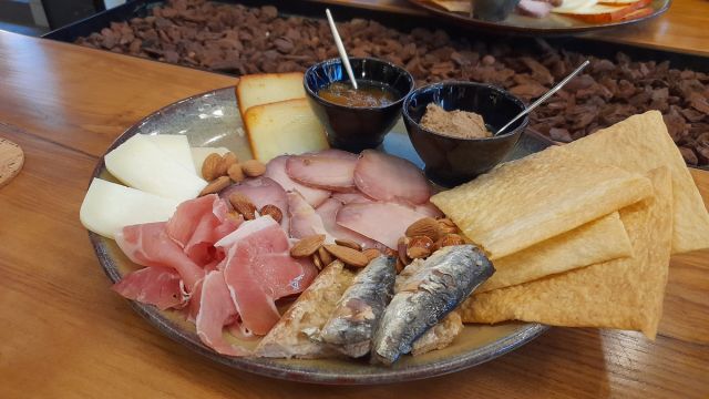 A delicious plate featuring savory meat, creamy cheese, and crunchy crackers, perfect for a food and wine tour in Portugal.