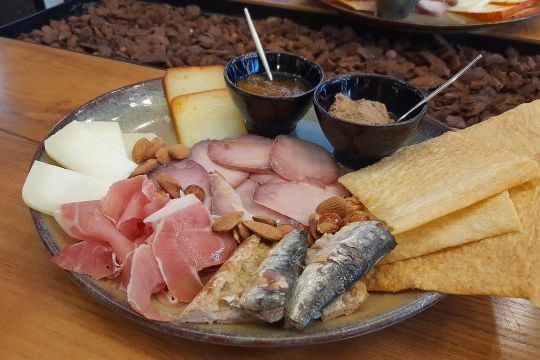 A delicious plate featuring savory meat, creamy cheese, and crunchy crackers, perfect for a food and wine tour in Portugal.