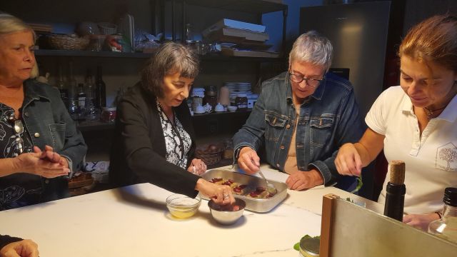 Enthusiastic participants gather in a cozy kitchen, cooking delicious Portuguese meals together on a culinary vacation.