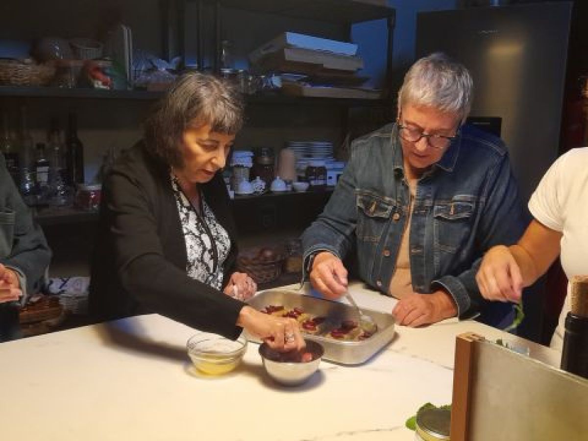 Enthusiastic participants gather in a cozy kitchen, cooking delicious Portuguese meals together on a culinary vacation.
