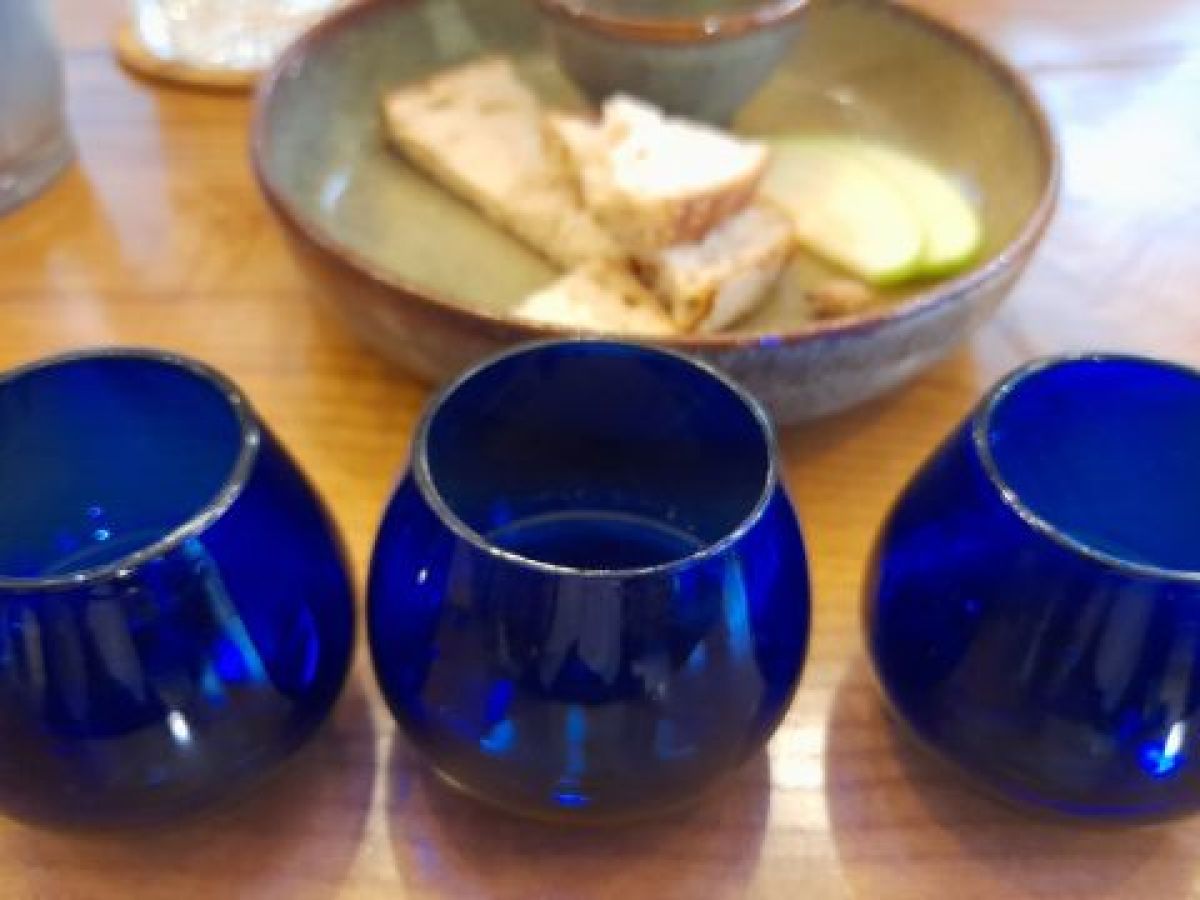 Three blue glass cups arranged on a wooden table, ready for a delightful Porto olive oil tasting session.