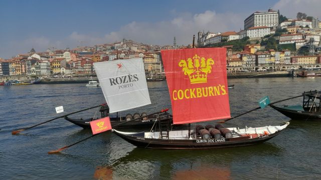 Two boats with sails drift on the Douro River, with Porto's beautiful skyline in view, ideal for exploring Portugal's charm.
