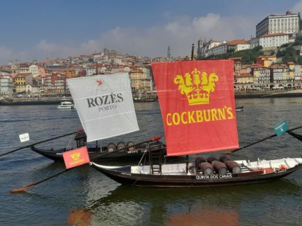 Two boats with sails drift on the Douro River, with Porto's beautiful skyline in view, ideal for exploring Portugal's charm.