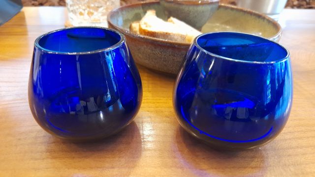blue glass cups arranged on a wooden table, ready for a delightful Porto olive oil tasting session.