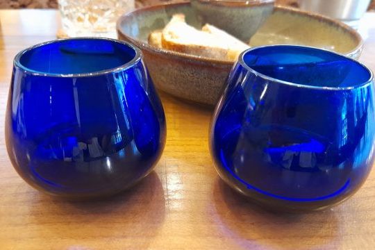 blue glass cups arranged on a wooden table, ready for a delightful Porto olive oil tasting session.